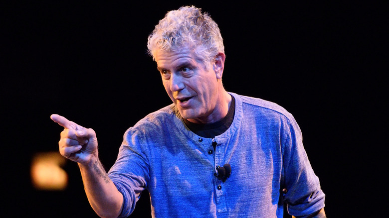 Anthony Bourdain giving a talk and pointing at the audience.