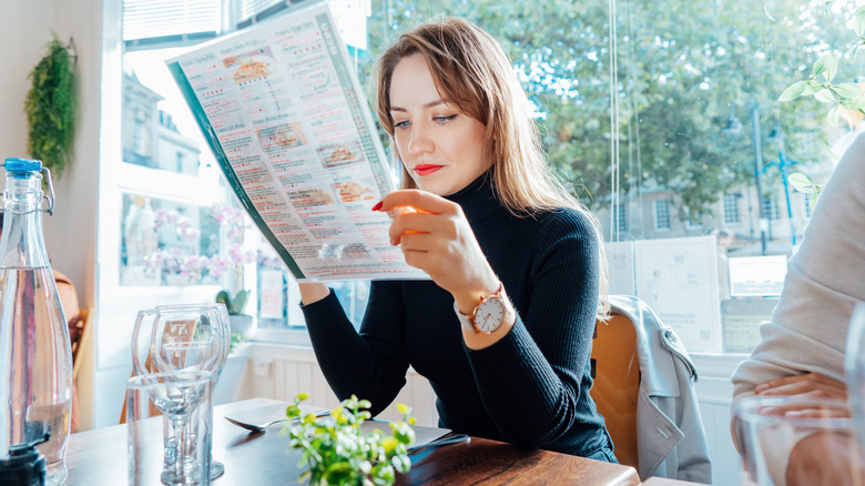A woman looks over the menu in a restaurant