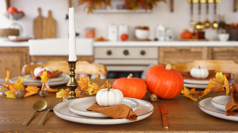 Kitchen table decorated for fall with candles and pumpkins