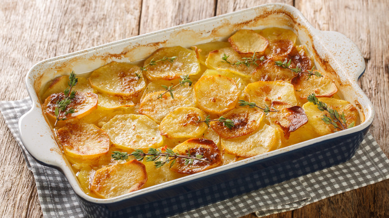 A pan of potatoes au gratin garnished with thyme