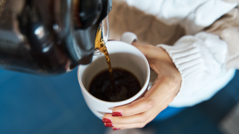 person pouring coffee into cup
