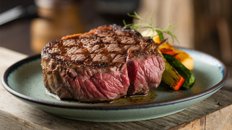 medium-rare steak with grilled vegetables on plate