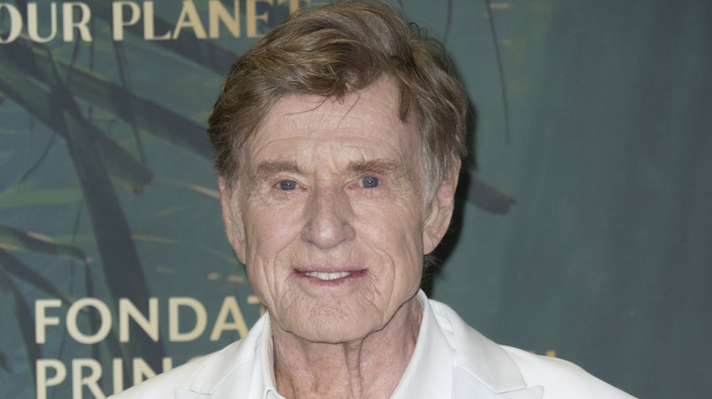 Robert Redford smiling in a white suit