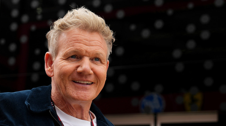 Gordon Ramsay smiling slightly as he talks to someone
