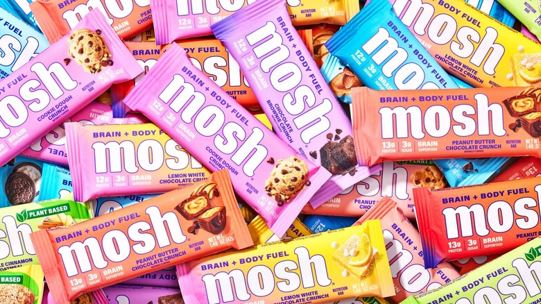 Various flavors of Mosh protein bars are piled together