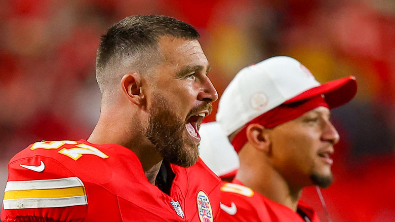 Travis Kelce and Patrick Mahomes stand on the sidelines in their Chiefs uniforms
