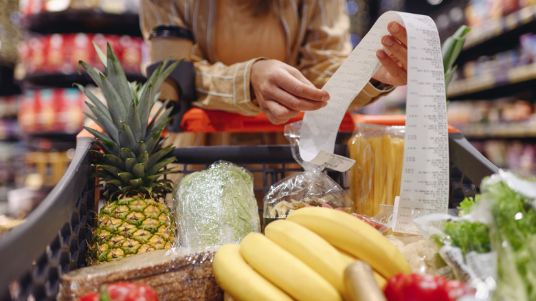 Grocery shopper with cart and receipt