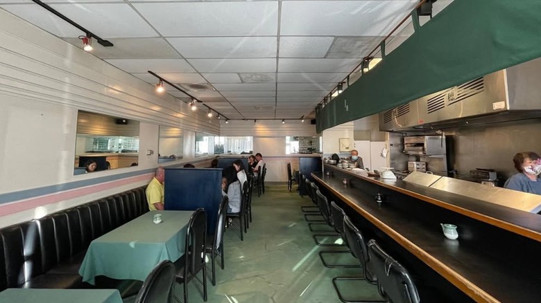 The interior of Kappo Sui, tables and chairs on the left, the counter and kitchen on the right