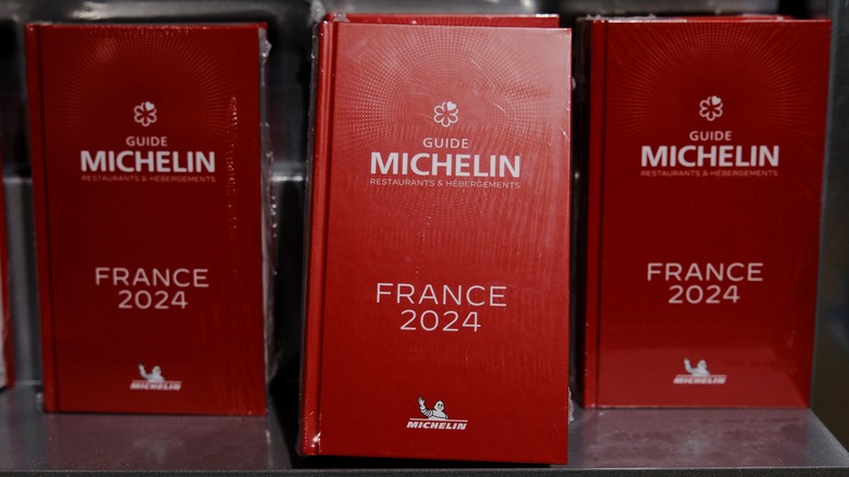 Three red books stand next to each other, with the Title "Guide Michelin"