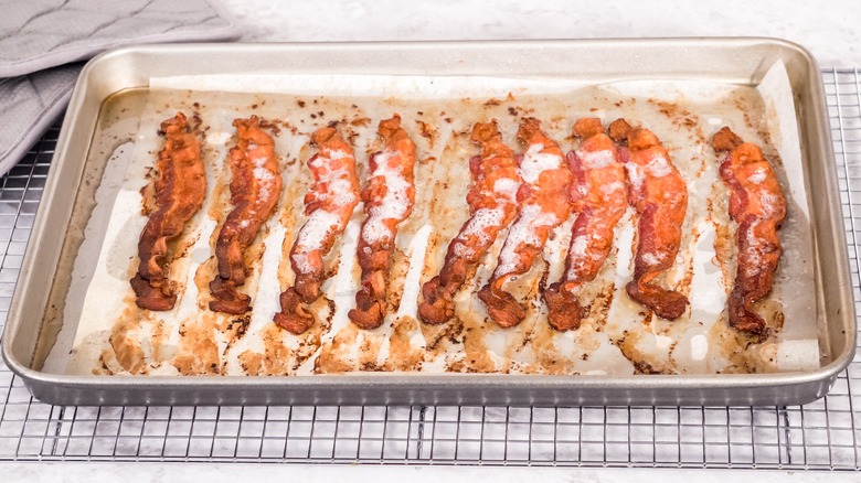 hands holding bacon package at store