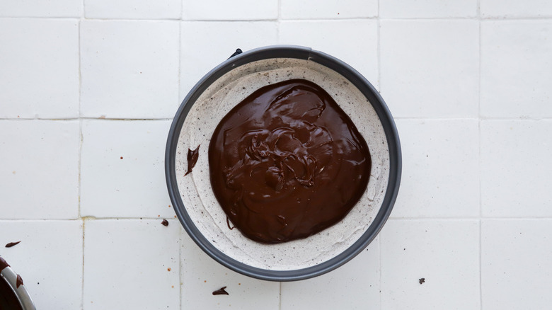 Pouring fudge topping on cake