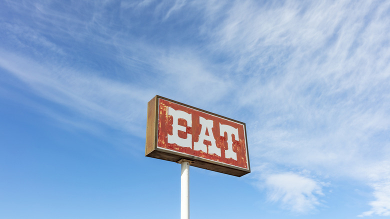Highway restaurant sign in front of blue sky