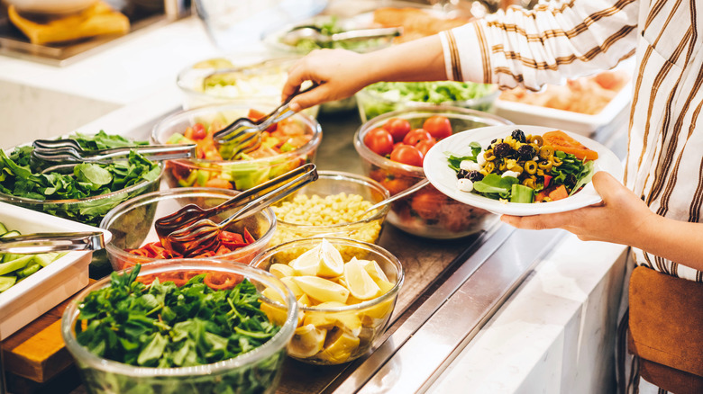 Woman choosing food from salad bar