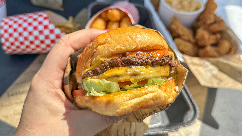 A burger from Jaggers with other foods in the background.