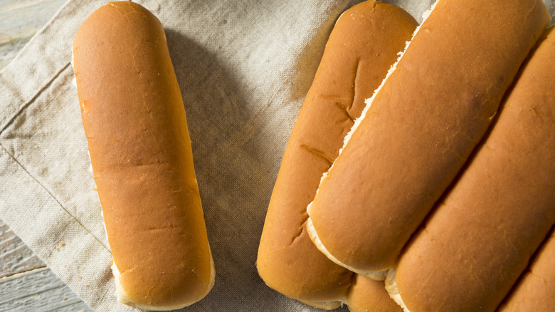 Hot dog buns sit on burlap napkins