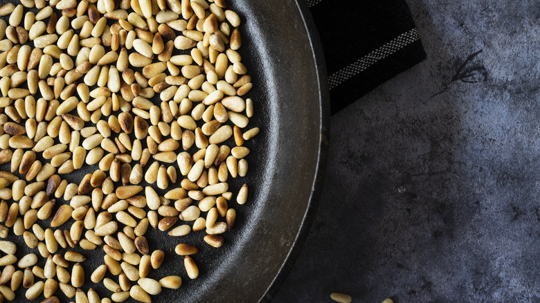 Toasted pine nuts in a cast-iron skillet
