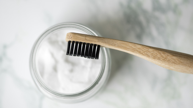 Bowl of baking soda with wooden bristle brush