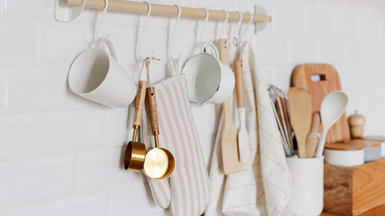 Wooden dowel with hooks holding variety of kitchen tools