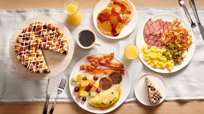 A table is spread with plates full of Golden Corral breakfast items