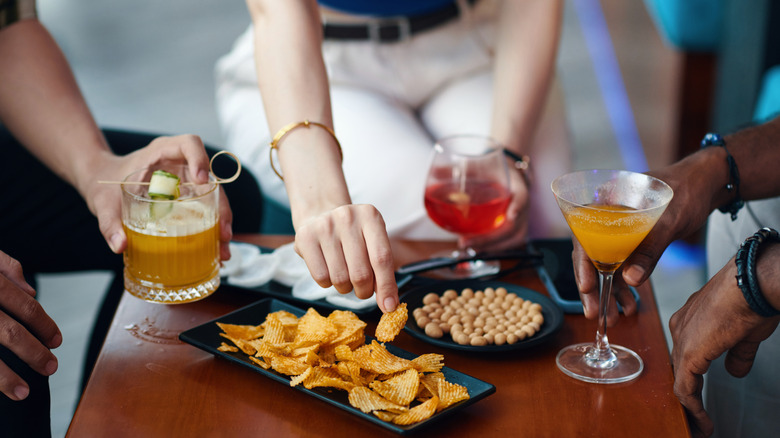 people enjoying drinks alongside snacks