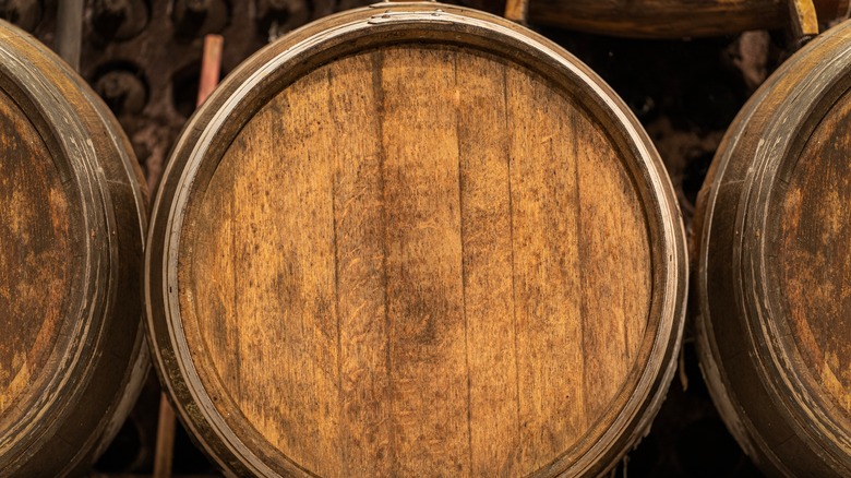 Bourbon aging in oak barrels in a line