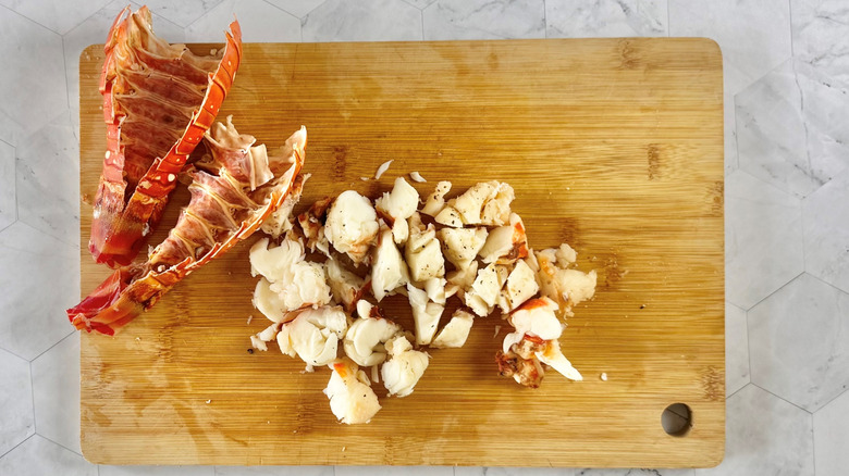 lobster shells with chopped meat on wooden board
