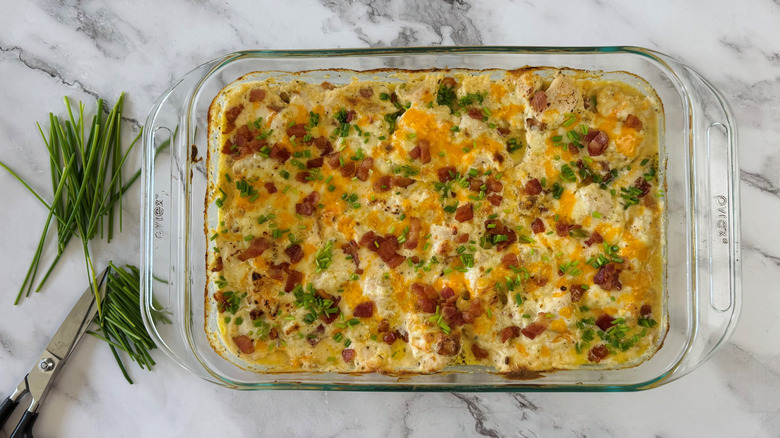 cheesy creamy chicken casserole with chive and bacon garnish