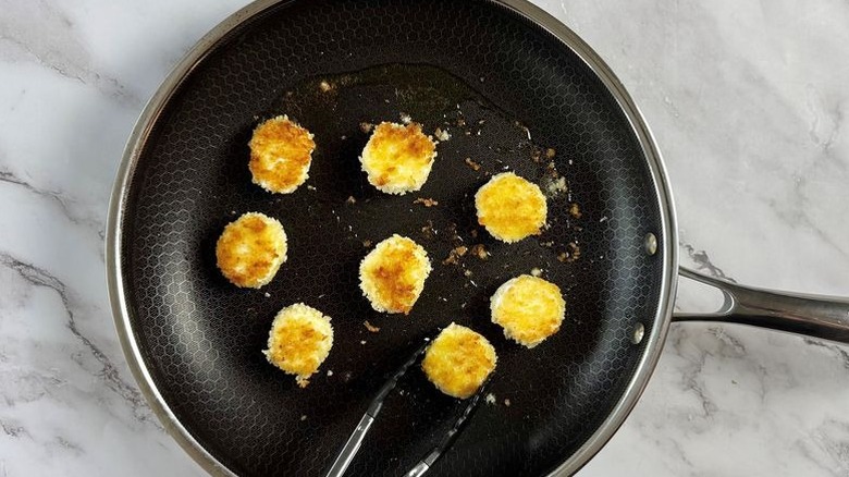 Breaded goat cheese slices in pan