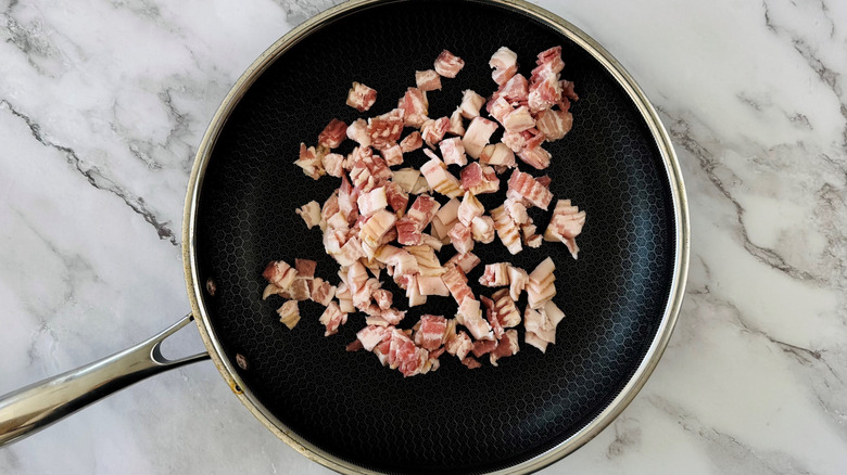 diced bacon cooking in skillet