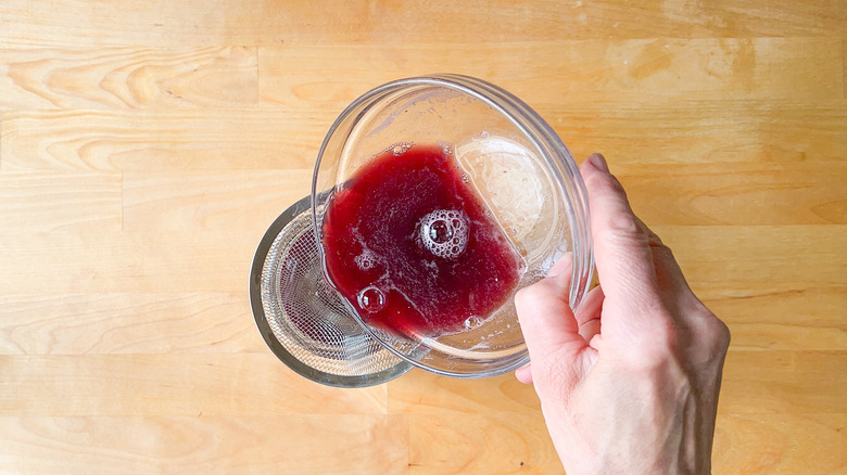 pouring wine through sieve