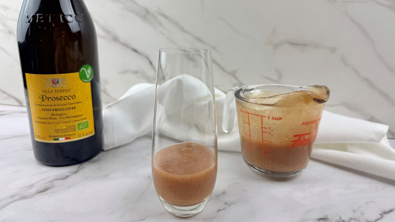 peach puree in a drinking glass and a glass measuring cup