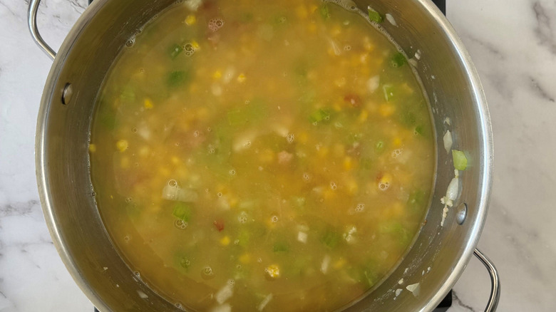 Large soup pot with broth and mixed veggies