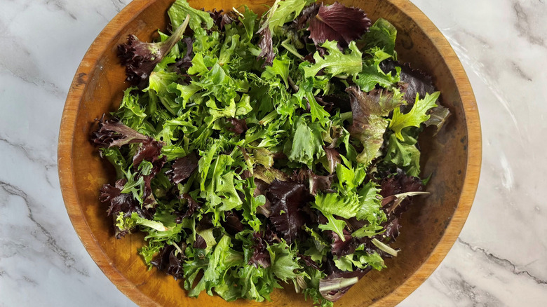 Mixed greens in wooden salad bowl