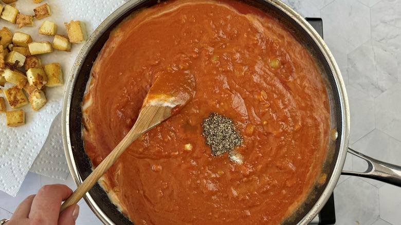 hand stirring tomato sauce
