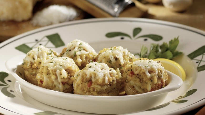 Olive Garden stuffed mushrooms topped with melted cheese served on a decorative plate