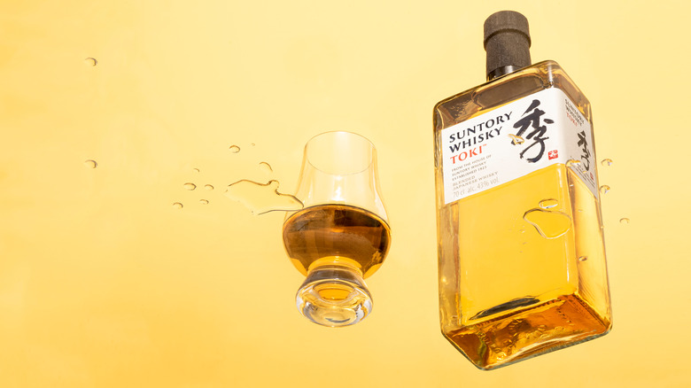 A bottle of Suntory Whiskey Toki with a glass of whiskey beside it