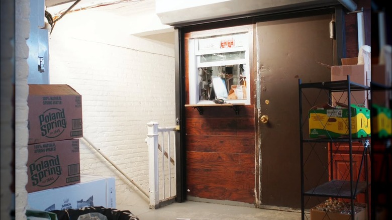 The exterior of 35 West, a small window in a door, in a hallway