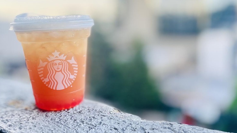 Starbucks Lemon, tea & pearls drink sitting on outdoor ledge