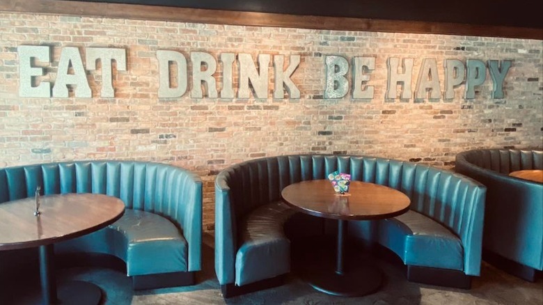 The interior of a Bar Louie restaurant with signage that reads, "eat drink be happy"