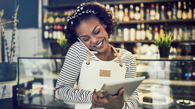 Woman holding iPad and talking on phone
