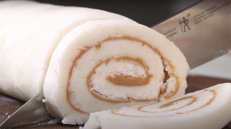 knife cutting roll of potato candy