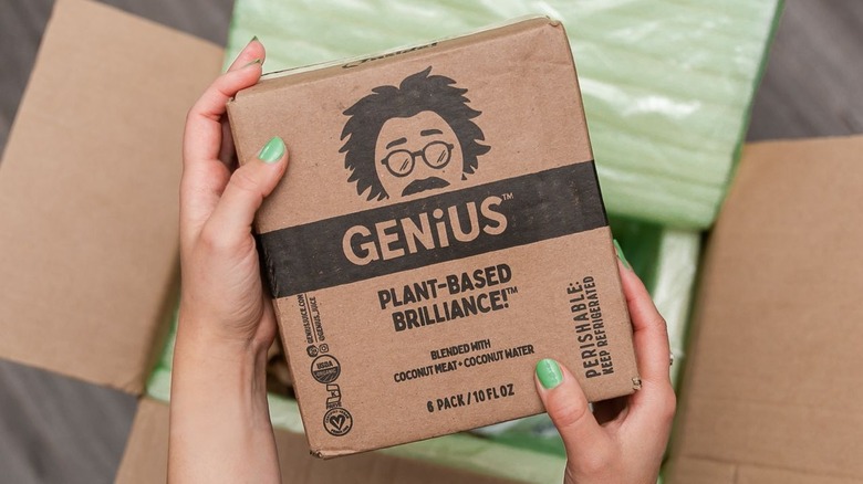 hands holding box of genius juice