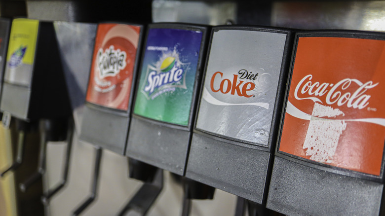 A close up on a Coca-Cola beverage dispenser with Coke, Diet Coke, Sprite, and a fruit punch option