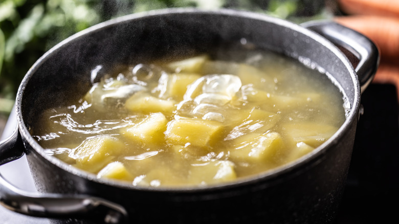 Boiling potatoes in a black pot